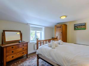 a bedroom with a bed with a dresser and a mirror at 3 bed property in Bridport 75334 in Frome Vauchurch