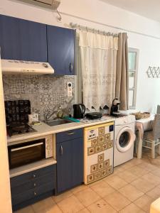 a kitchen with a sink and a washing machine at Studio Filareti in Ios Chora