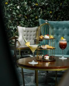 uma mesa com uma bebida e uma gaiola com sobremesas em City Hotel by Waves em Kenitra