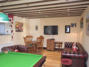 a living room with a pool table and a tv at 2 Bed in Corwen 77351 in Corwen