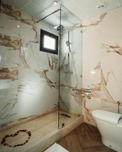 uma casa de banho com um WC e uma cabina de duche em vidro. em City Hotel by Waves em Kenitra