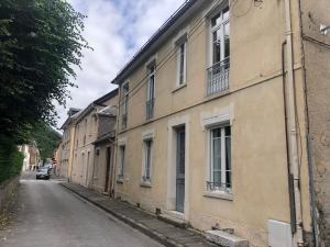 an empty street in a city with a building at Luchon centre - maison de ville calme et lumineuse in Luchon