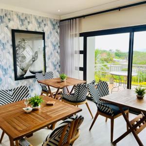 a restaurant with wooden tables and chairs and a balcony at Blue View B&B in East London