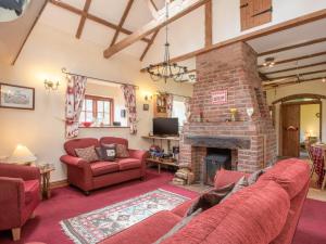a living room with red furniture and a brick fireplace at 3 bed in South Creake KT099 in South Creake