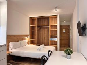 a small room with two beds and two tables at Outdoor Apartaments - Spot in Andorra la Vella