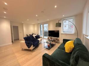 a living room with a green couch and chairs at Glitz and Luxury in London