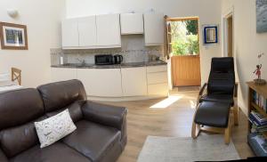 a living room with a couch and a kitchen at The Snicketts in Ludlow