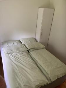 an unmade bed in a room with a white wall at Sivert´s kontorhotell in Tomrefjord +5 photos