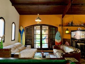 a living room with a couch and surfboards on the wall at Guaru Surf Hostel in Guarujá