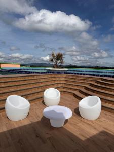 trzy białe ławki siedzące na dachu budynku w obiekcie ALTO VERDE HOTEL w mieście Guatapé