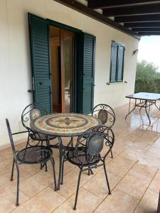 an outdoor table and chairs on a patio at Villa al Presti, Vacanze in pieno relax in Cefalù