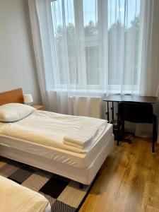a bedroom with a bed and a desk and windows at Hotel Akor in Bydgoszcz