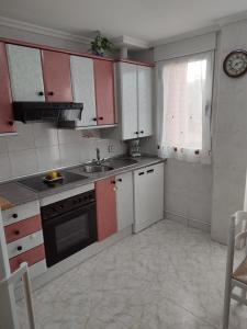 a kitchen with red and white cabinets and a sink at Vivienda Almanzor in Salamanca