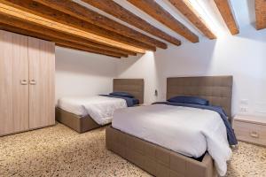 2 camas num quarto com tectos em madeira em Ca' Superba em Veneza