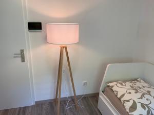 eine Lampe neben einem Bett in einem Zimmer in der Unterkunft Apartment im Herrenwäldchen in Brombachtal