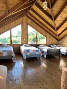 Habitación con 4 camas en un edificio de madera en Cabaña Rancho Don Marino, en Cartago