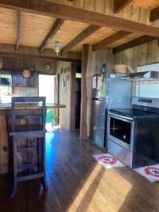a kitchen with a stainless steel refrigerator and a counter at Cabaña Rancho Don Marino in Cartago