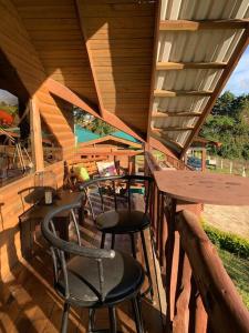a porch with two chairs and a table on a deck at Cabaña Rancho Don Marino in Cartago