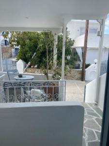 a table and chairs on a patio with a house at Studio Filareti in Ios Chora