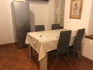 a dining room table with chairs and a refrigerator at Casa Weber Levico Terme in Levico Terme