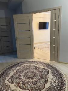 Zimmer mit einer offenen Tür und einem Teppich auf dem Boden in der Unterkunft 3х комнатная квартира in Taschkent
