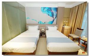 a hotel room with two beds and a painting on the wall at pristine848 in Manila