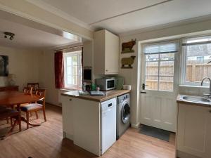 uma cozinha com uma máquina de lavar e secar roupa e uma mesa em Cottages at Woodlands, Dormer em Wareham