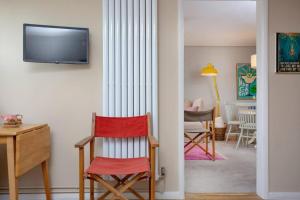 a room with a chair and a desk and a television at Western Court Sidmouth close to town and beach in Sidmouth