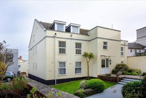 a white house with a palm tree in front of it at Western Court Sidmouth close to town and beach in Sidmouth