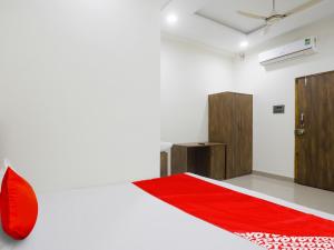 um quarto com uma cama vermelha e um tapete vermelho em OYO Flagship Hotel Rahul Service Appartment 2 em Nagpur