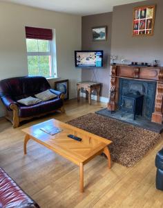 a living room with a coffee table and a fireplace at Glencolumbkille House - Self Catering Rooms in Glencolumbkille