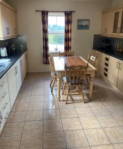 a kitchen with a table and chairs and a window at Glencolumbkille House - Self Catering Rooms in Glencolumbkille