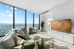 sala de estar con sofá y ventanas grandes en The Seabreeze - Lv 67 King Bed 2BDR Netflix Pool, en Gold Coast