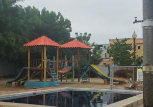 um parque infantil com um escorrega e um gazebo em Paraíso Costero en Alquiler em Playas