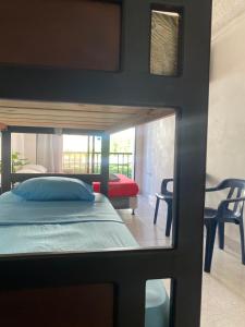 Habitación con vistas a un dormitorio con cama y silla. en Posada Casamar 2, en San Andrés