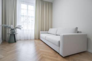 a white living room with a white couch and a window at Laurinska 1 Apartments in Bratislava