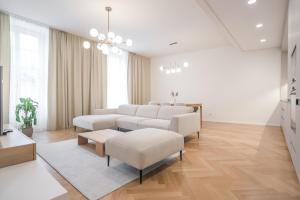 a living room with white furniture and wooden floors at Laurinska 1 Apartments in Bratislava