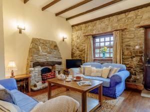 a living room with a blue couch and a stone fireplace at 1 bed property in Gower 77980 in Penclawdd