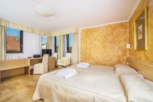 a hotel room with a bed and a desk and window at Hotel Roma Prague in Prague