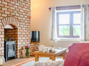 a living room with a brick fireplace and a table at 3 bed in Builth Wells 78329 in Crickadarn
