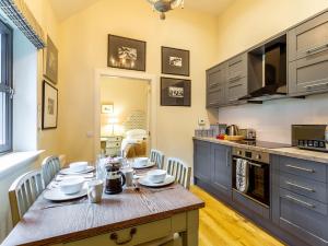 a kitchen with a wooden table with chairs around it at 1 Bed in Forres 78430 in Forres