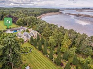 an aerial view of a house with trees and a beach at 1 Bed in Forres 78430 in Forres