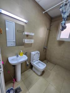 a bathroom with a toilet and a sink at Small single room inside luxurious villa in Dubai