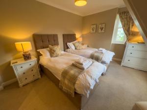 a bedroom with two beds and two night stands at Geltsdale East Wing in Carlisle