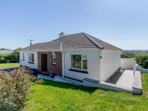 a small white house with a green lawn at 3 bed property in Bude 78213 in Ashwater