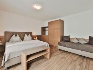 ein Schlafzimmer mit einem Bett und einem Sofa in der Unterkunft Apartment Chalet Sofie-2 by Interhome in Ischgl