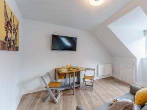 uma sala de estar com uma mesa e uma televisão na parede em 1 Bed in Brockenhurst 78730 em Brockenhurst