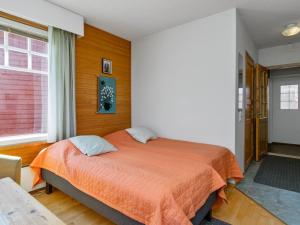 1 dormitorio con 1 cama con manta naranja en Holiday Home Moitakuru a4 by Interhome, en Saariselkä