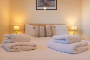- une chambre avec un lit et des serviettes dans l'établissement Stylish short-term let in Bucks, à Loudwater