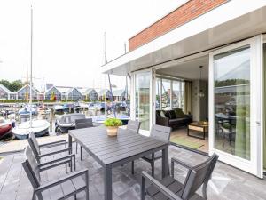 a patio with a table and chairs and boats at Holiday Home De Meerparel by Interhome in Uitgeest